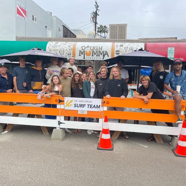 A large group of young people from the UC San Diego Surf Team gathered outside Dough Momma Pizzeria.